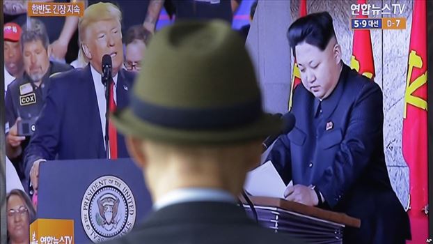 FILE - In this May 2, 2017, file photo, a man watches a television screen showing U.S. President Donald Trump, left, and North Korean leader Kim Jong - کره شمالی آماده گفت و گو با آمریکا درباره خلع سلاح هسته‌ای است