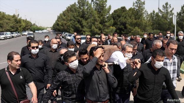 Iranians wearing protective face masks carry a coffin during a funeral ceremony, following the outbreak of the coronavirus disease (COVID-19), in Tehr - 
